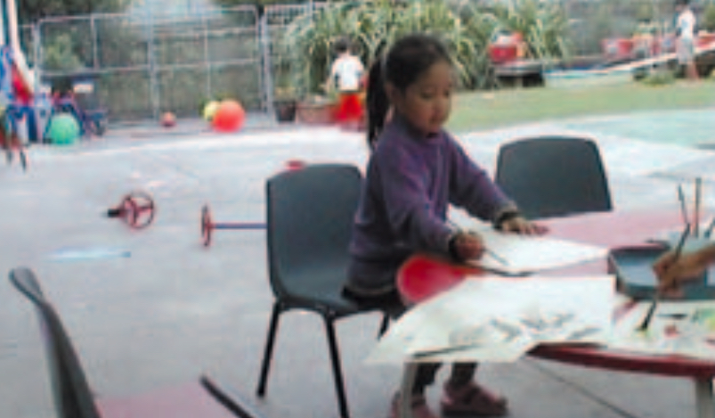 Girl drawing at table outside