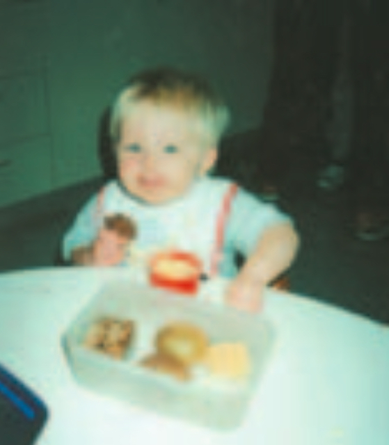 Blond infant boy eatingn lunch out of lunchbox