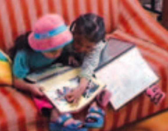 Two girls reading a book together