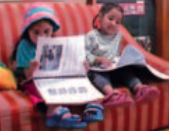 Two girls reading a book together