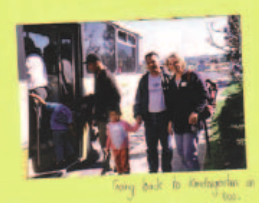 Child getting on a bus with three adults