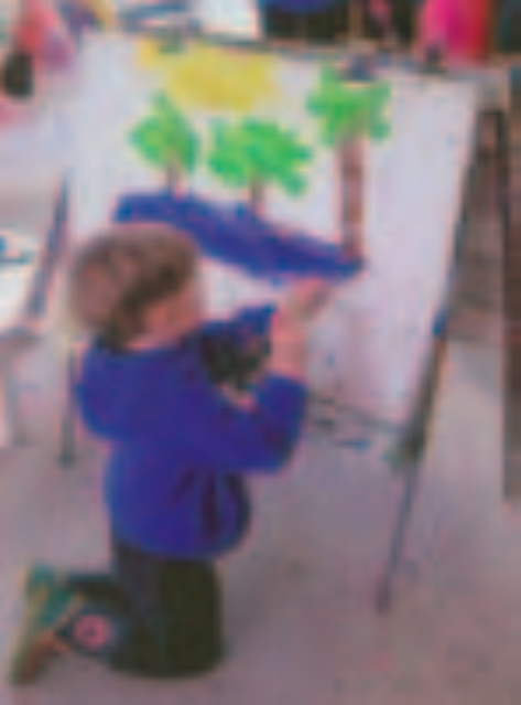 Boy painting a picture of trees