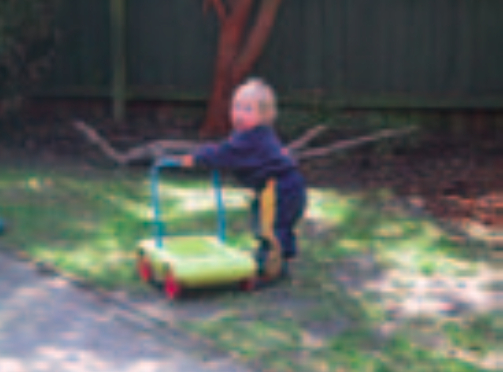 Infant girl pushing a toy trolley
