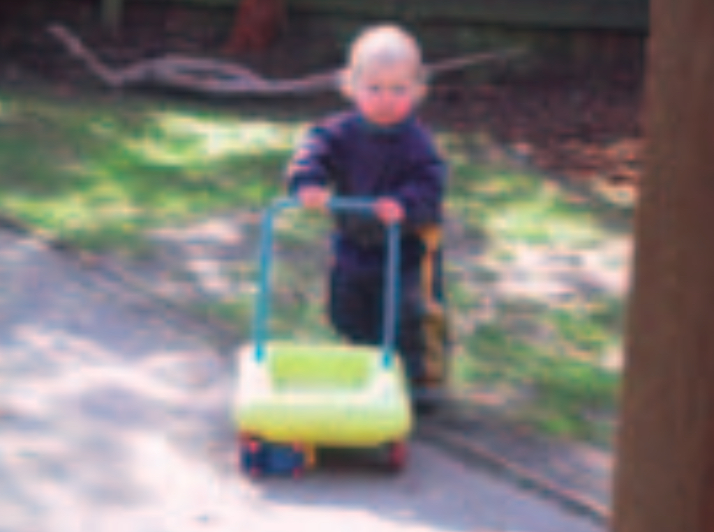 Infant girl pushing a toy trolley