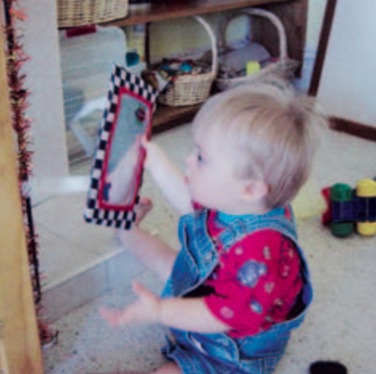 Infant boy looking at own reflection