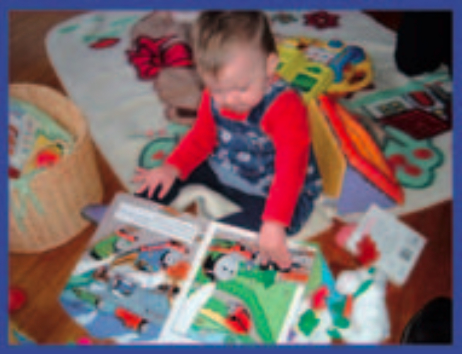 Infant girl looking at picture book