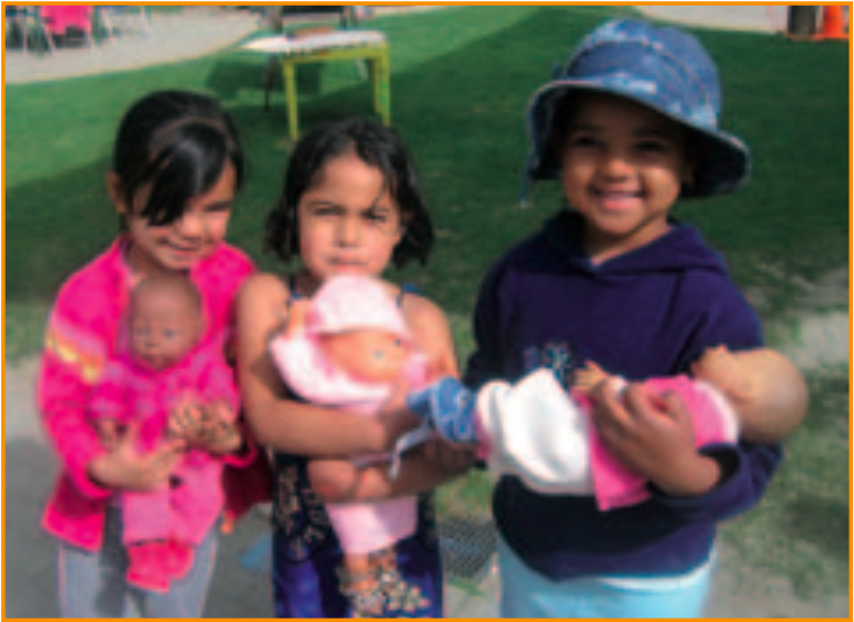 Three children holding dolls