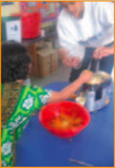 Teacher and child using an electric juice-maker