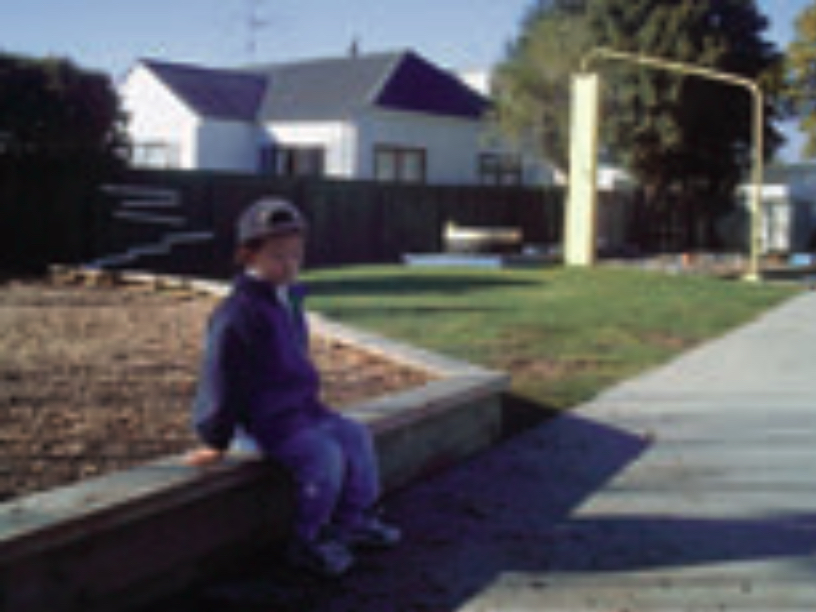 Child sitting by sidewalk