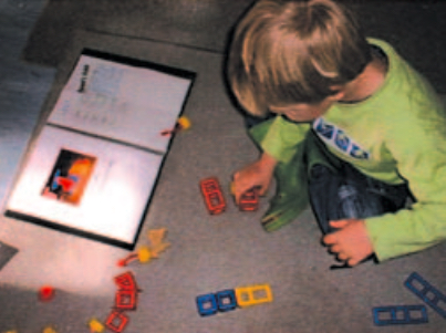 Child creating construction from photograph