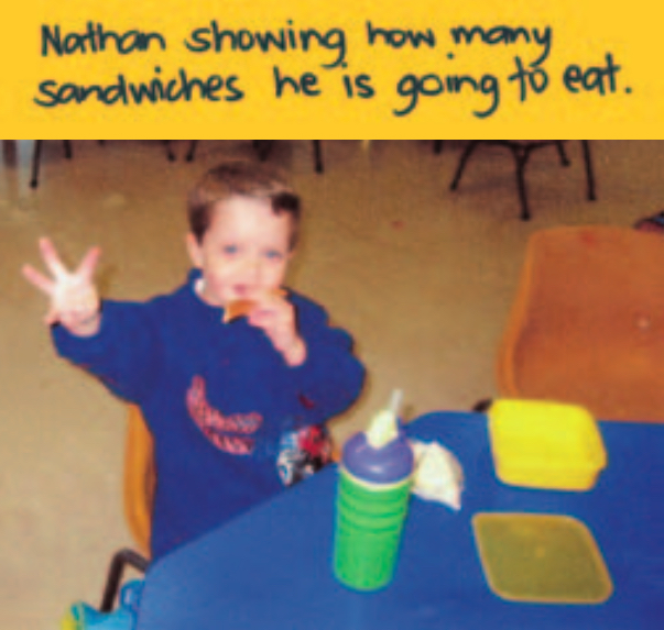 Boy eating sandwiches at a table
