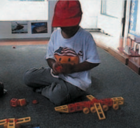 Boy creating a plastic, multicoloured model plane