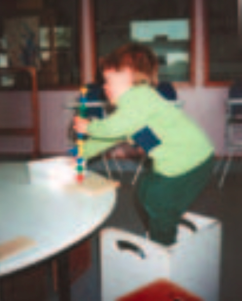 Infant boy playing with construction set on table