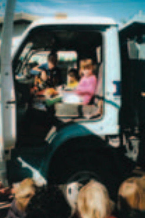 Children inside the cab of a real truck with driver