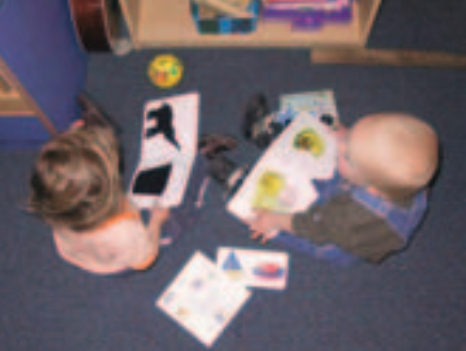 Two infant boys looking at books