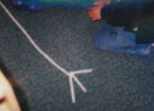 Child sticking masking tape to floor